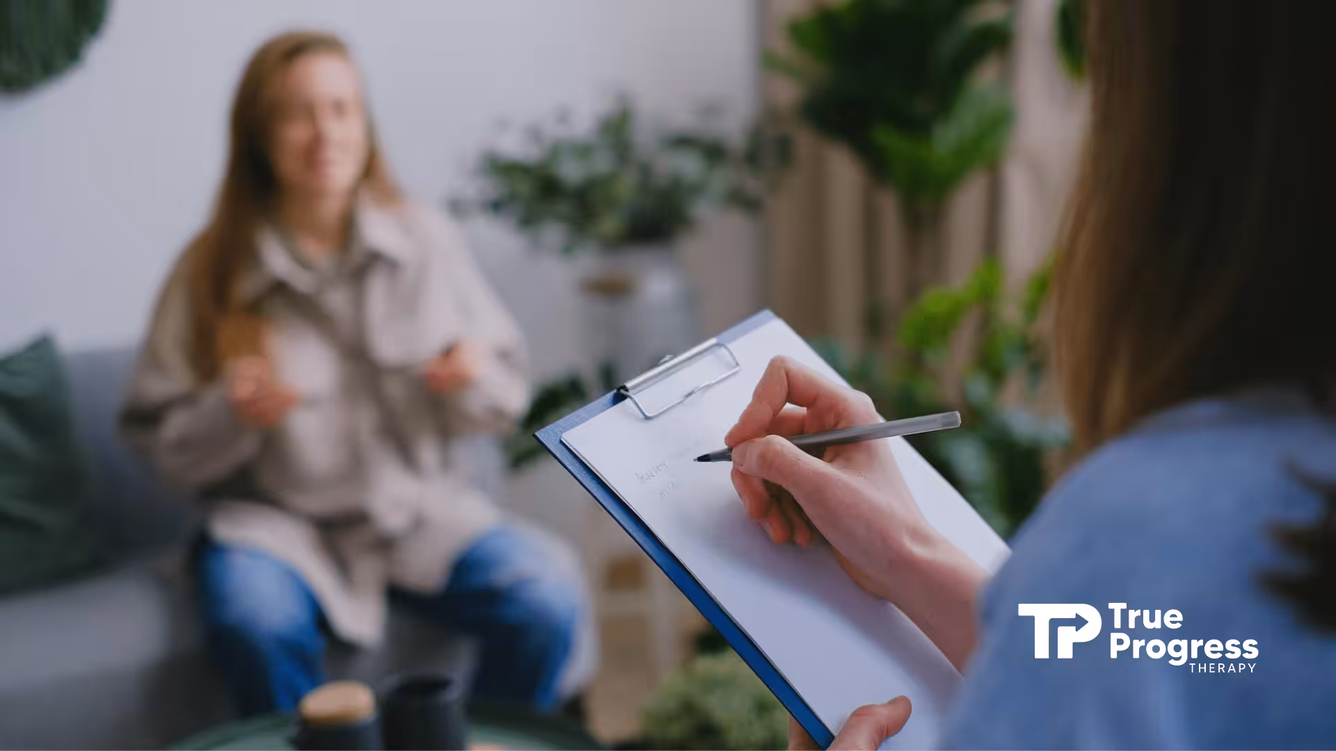 An ABA therapist writes while listening to an autistic woman speaking during ABA therapy in NJ.