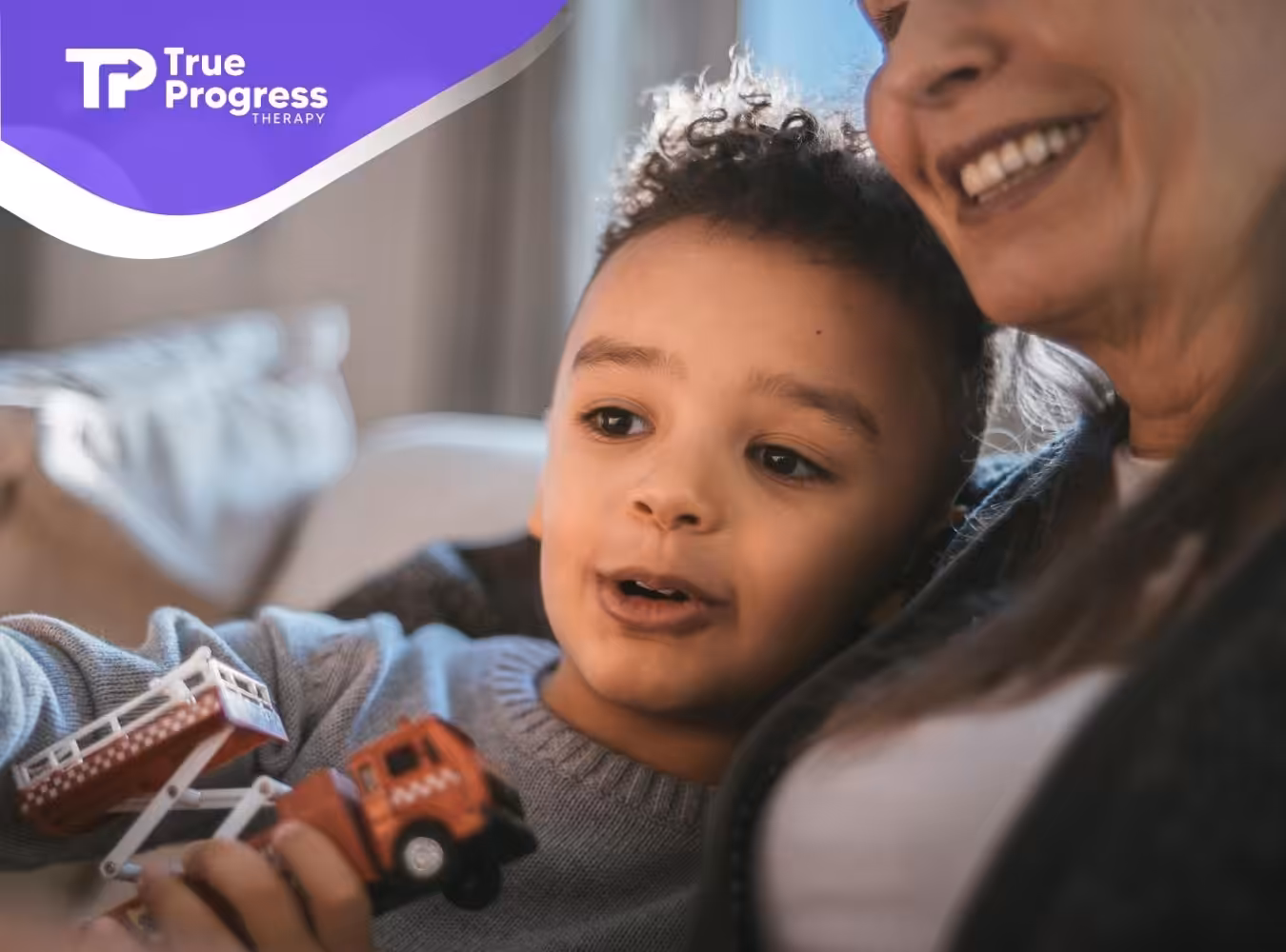 An autistic boy holding a red toy fire truck sits with smiling RBT during ABA therapy in New Jersey.