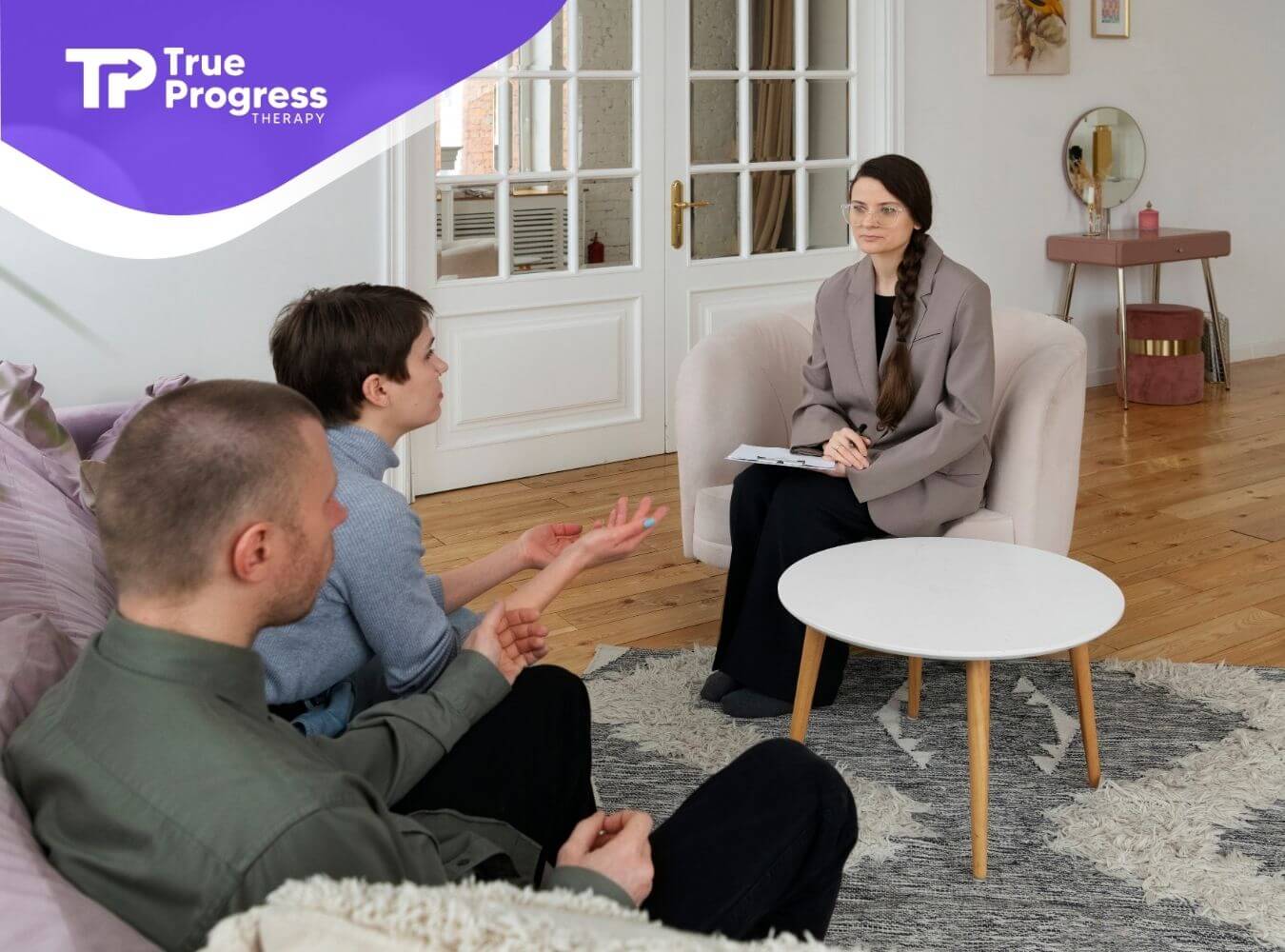Therapist listening attentively to parents during a counseling session focused on child development and family support