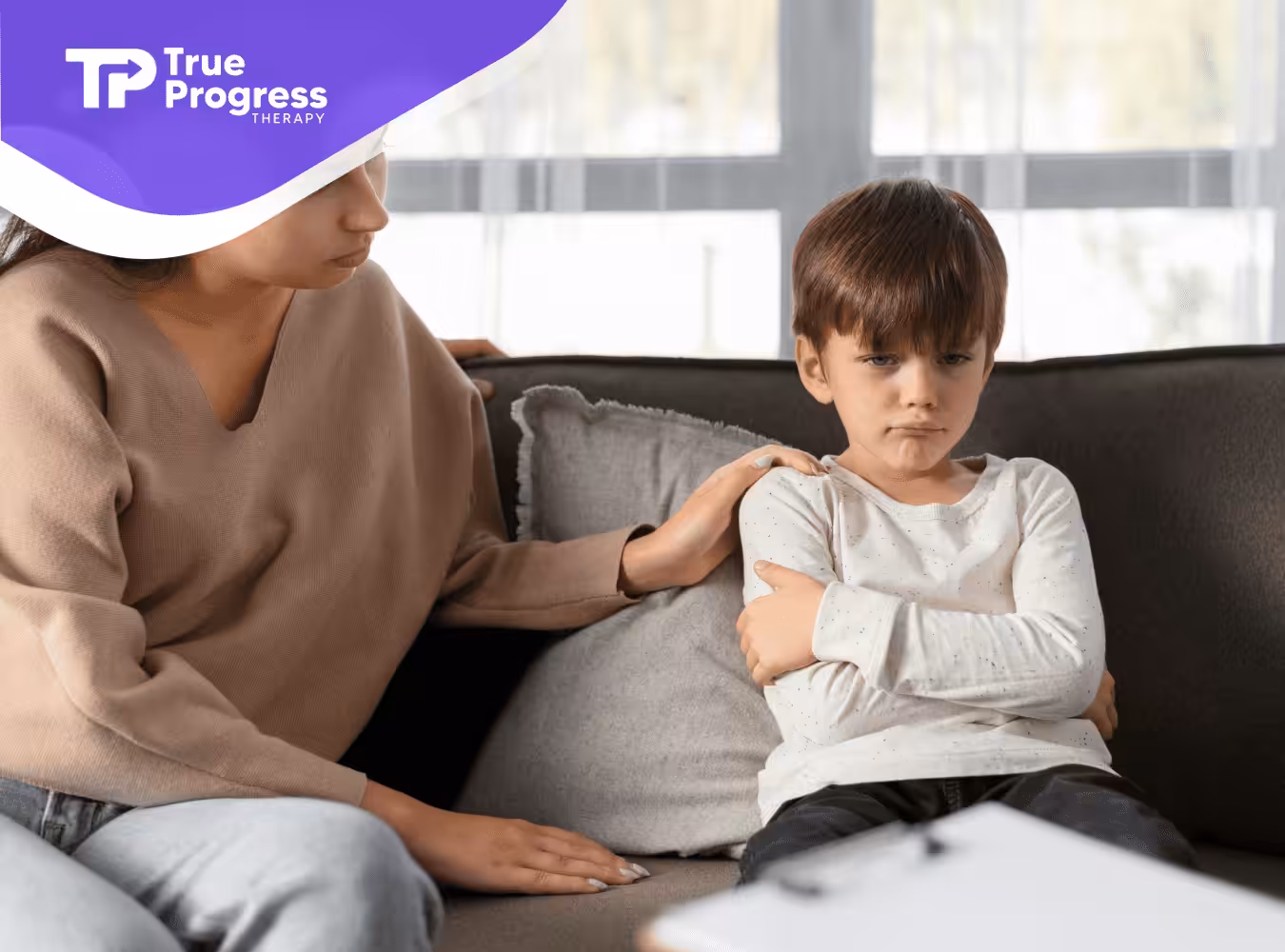 A child throwing a tantrum being comforted by his mom