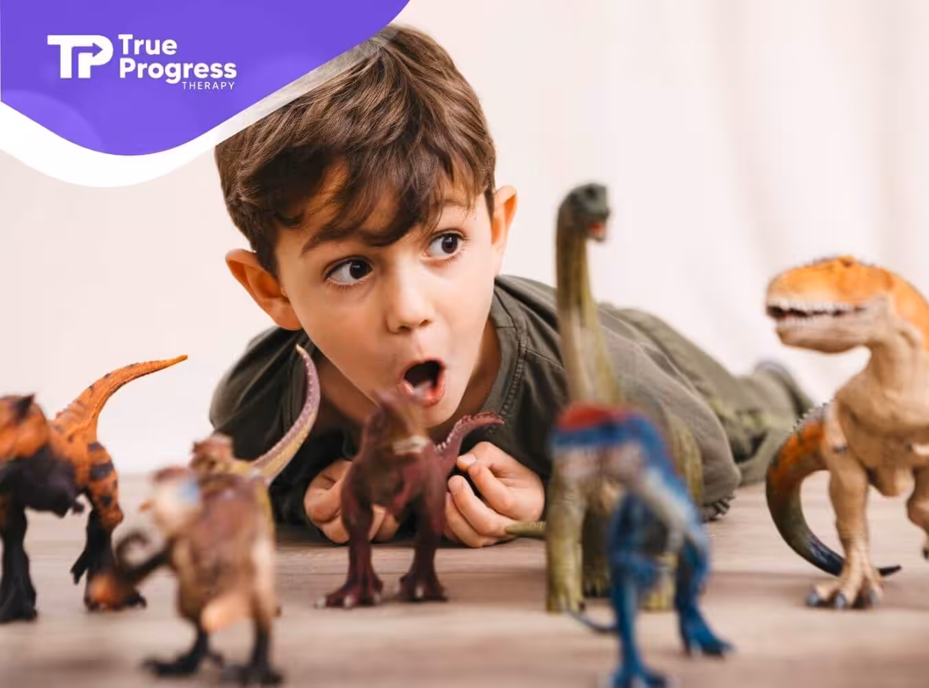 Autistic boy playing with dinosaur toys in ABA therapy.