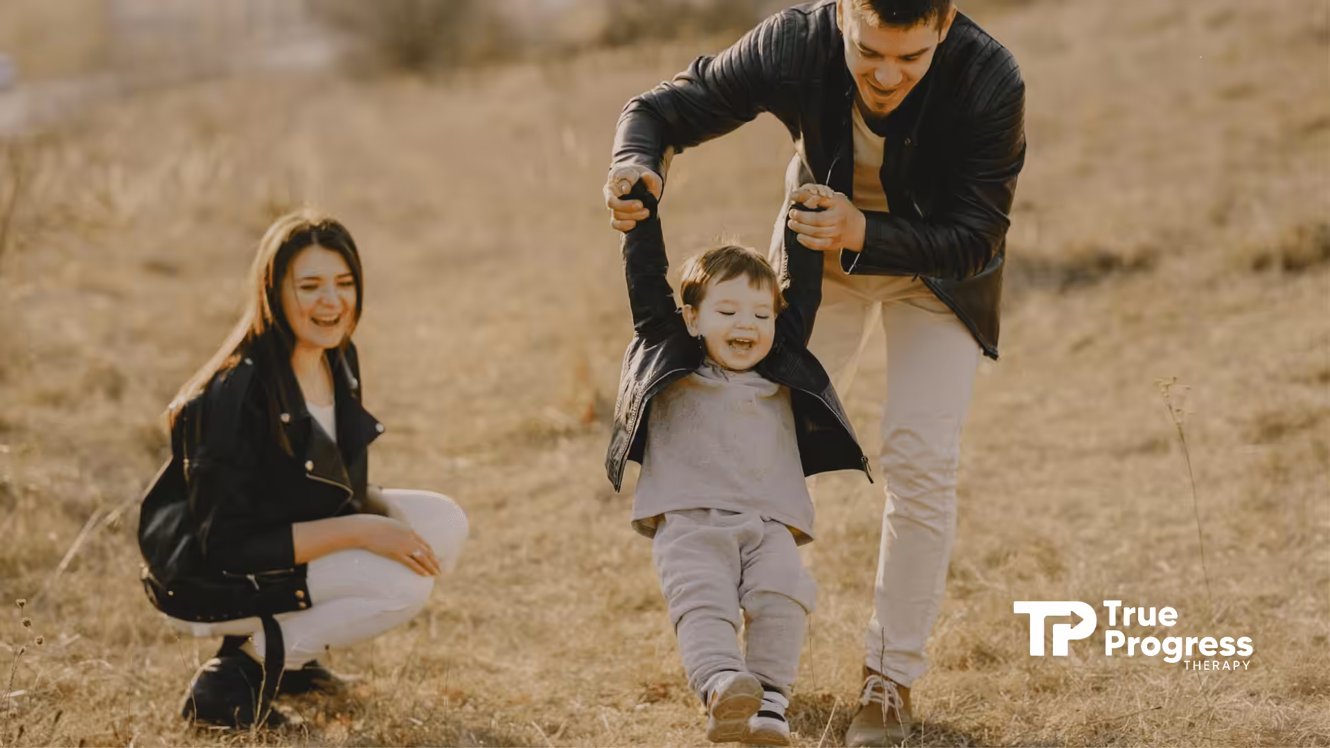 A mother and a father playing soccer outdoors in New Jersey with their cheerful autistic child.