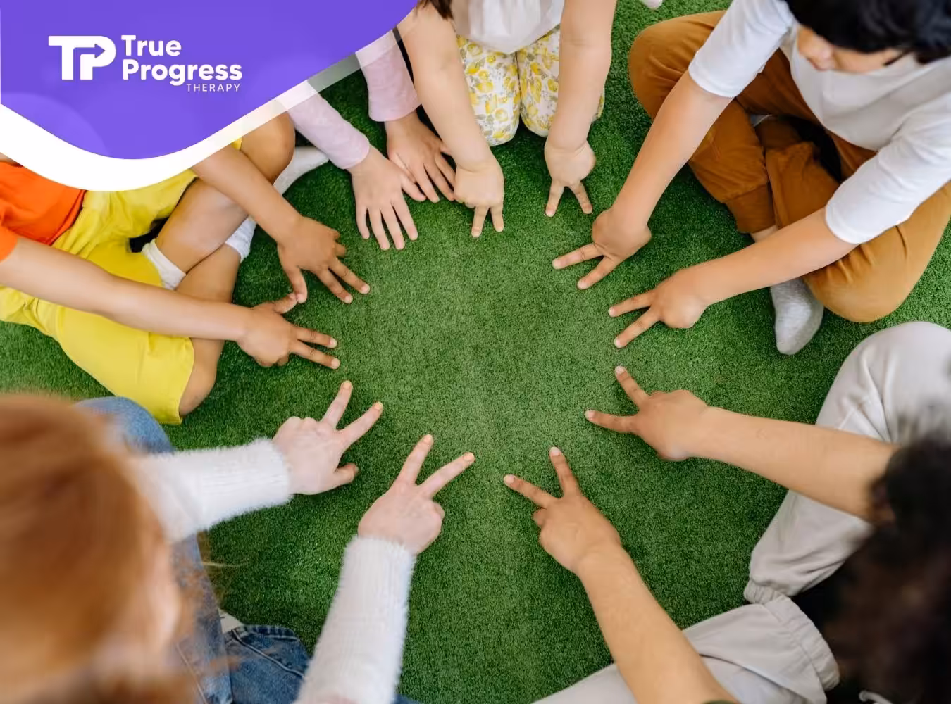 Children with autism sitting in a circle on green grass, participating in a group activity in NJ.