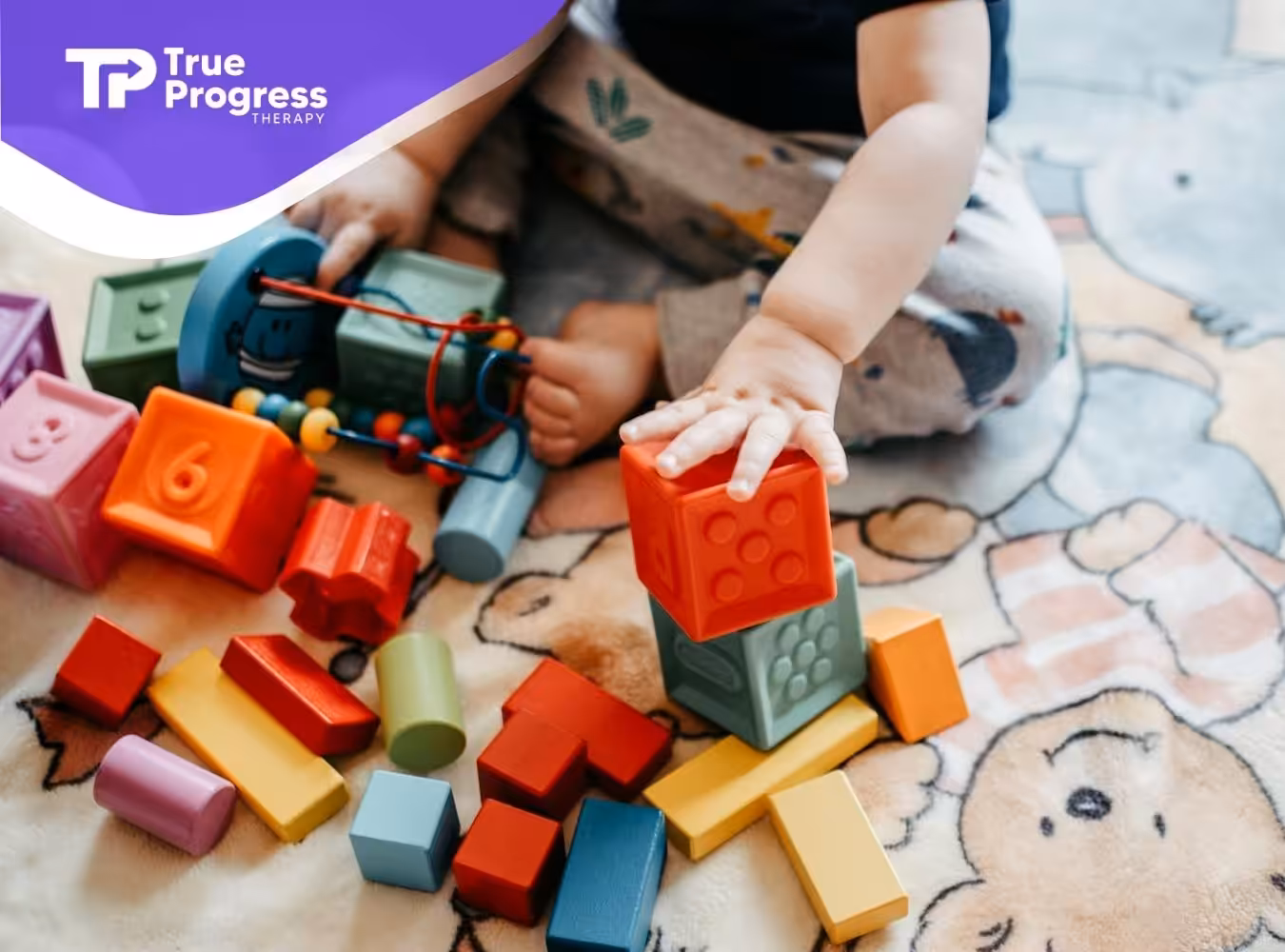 An autistic toddler with OCD stacking colorful toy blocks on a patterned playmat in New Jersey.