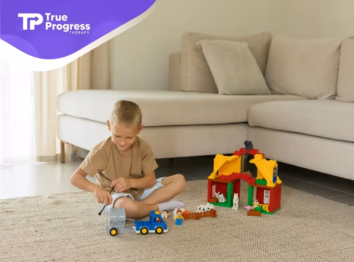 An autistic boy sits on a rug playing with a toy truck and colorful LEGO house near a couch in NJ.
