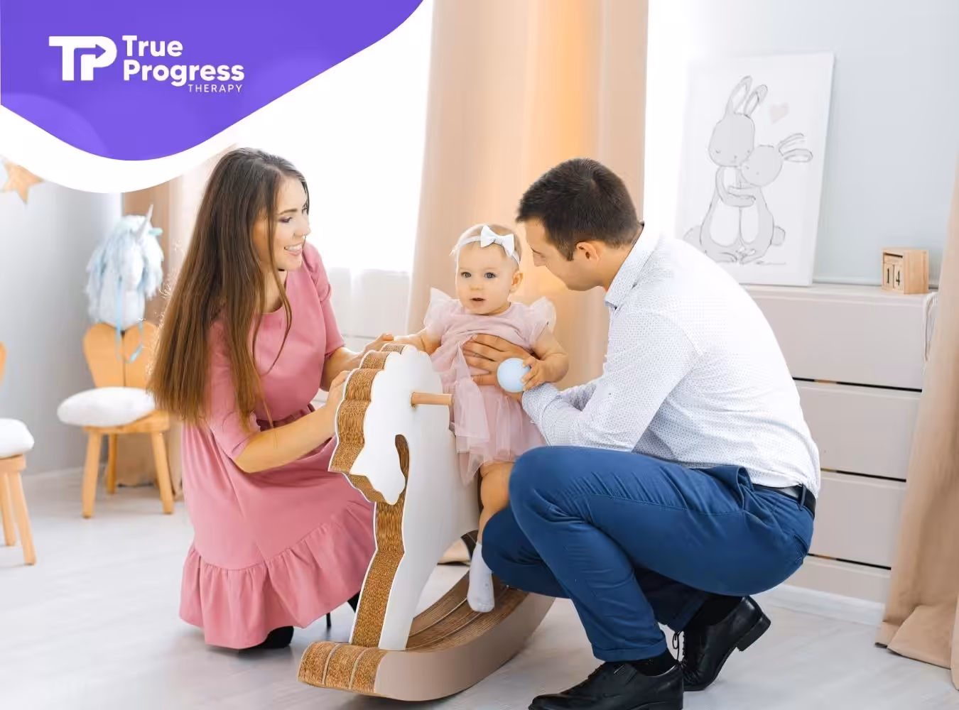 Smiling couple helps their toddler on a rocking horse in a bright and cozy nursery.