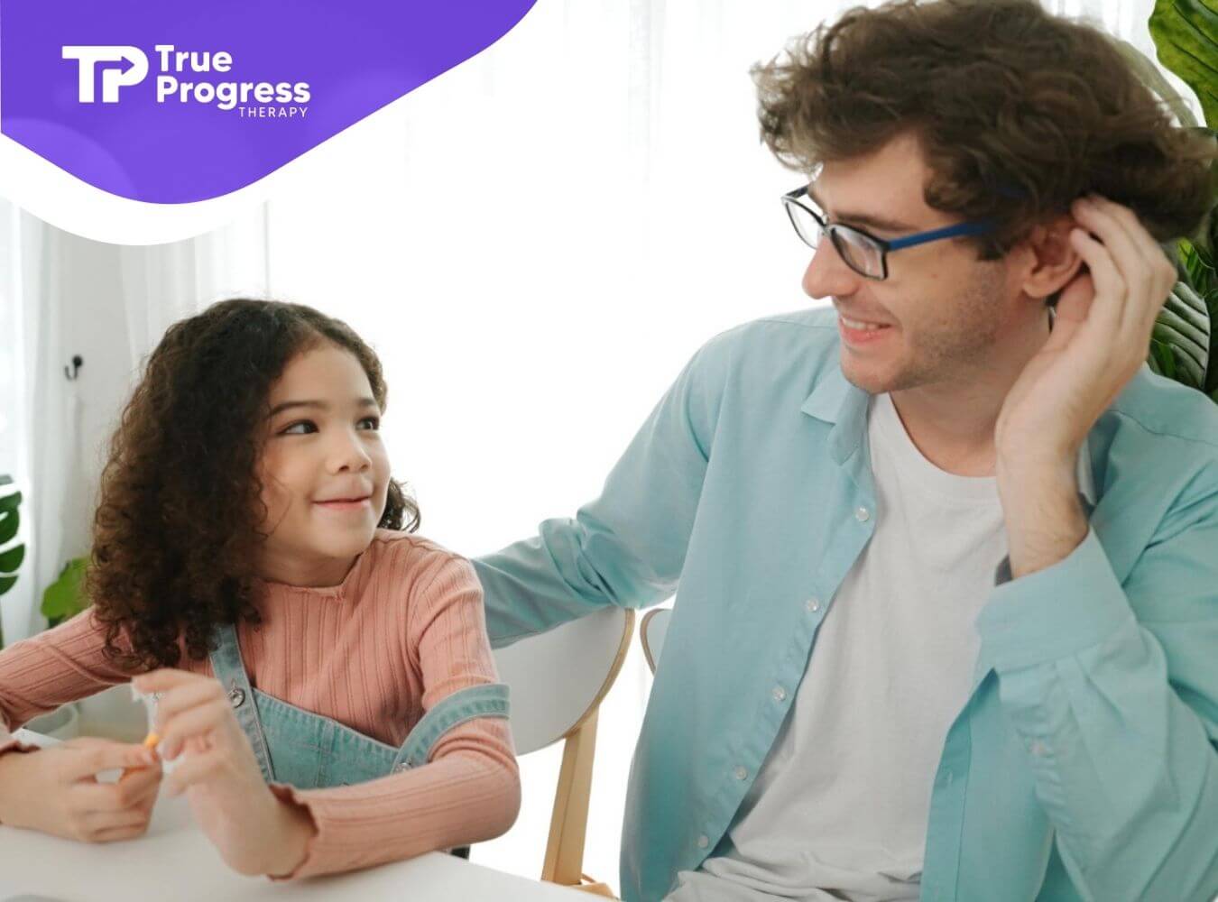 A BCBA and a young girl sitting at a table in ABA therapy session in NJ.