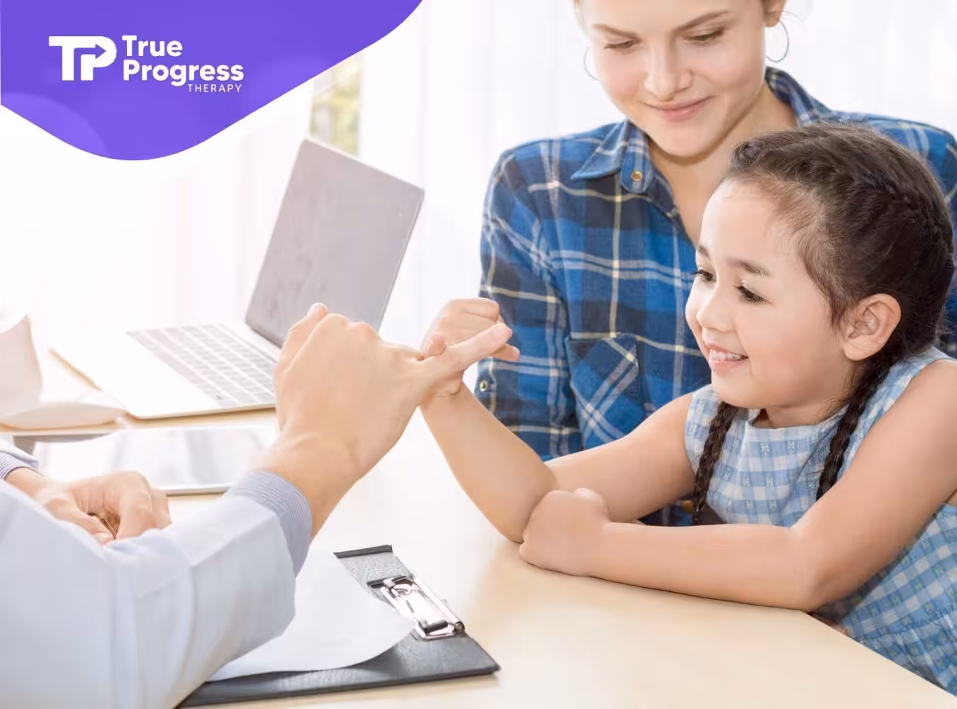 Smiling young girl interacts with a pediatrician leaning Autism Diagnostic Observation Schedule (ADOS) while her mother watches.