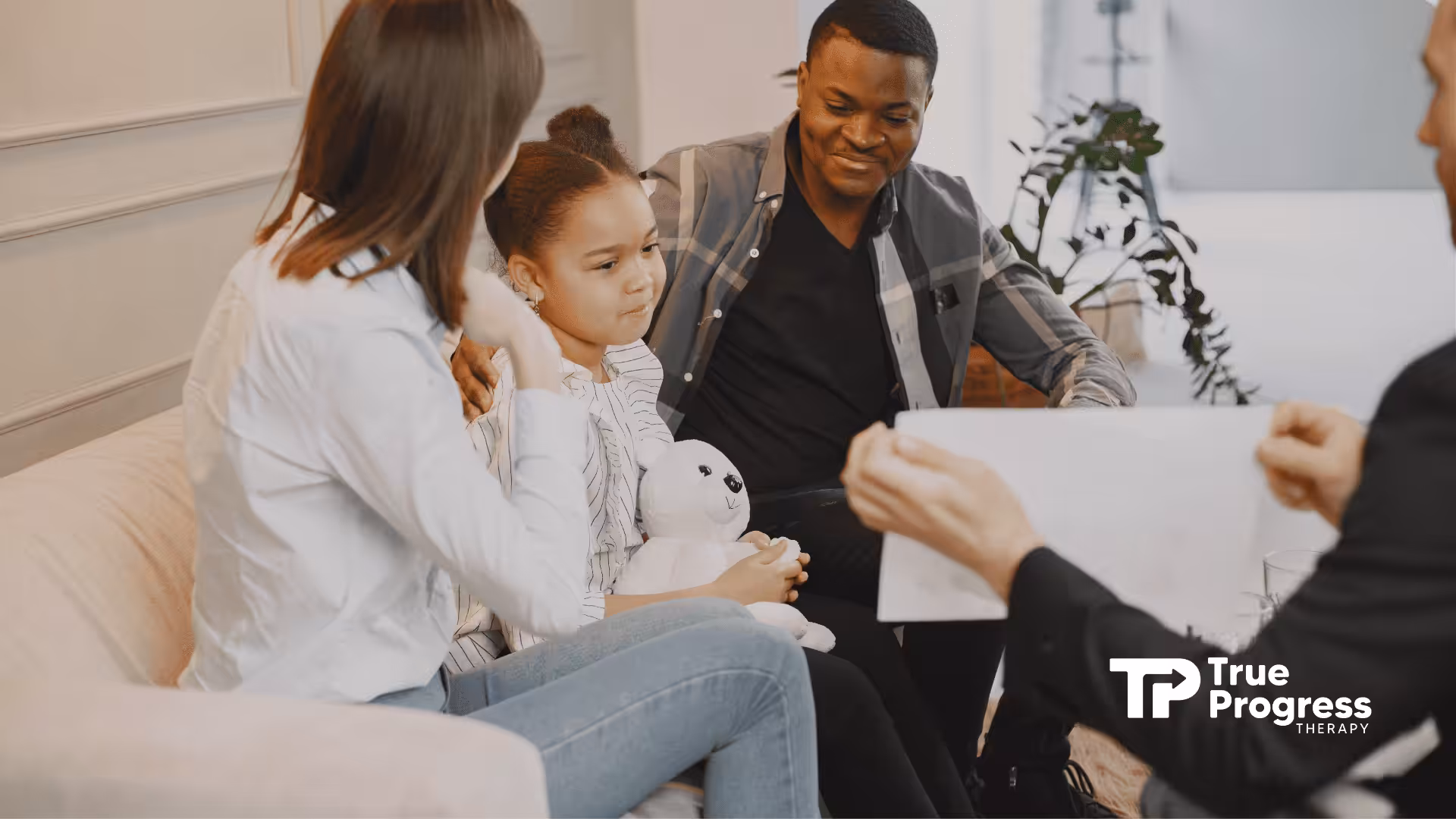 Parents and their autistic daughter during ABA therapy session.