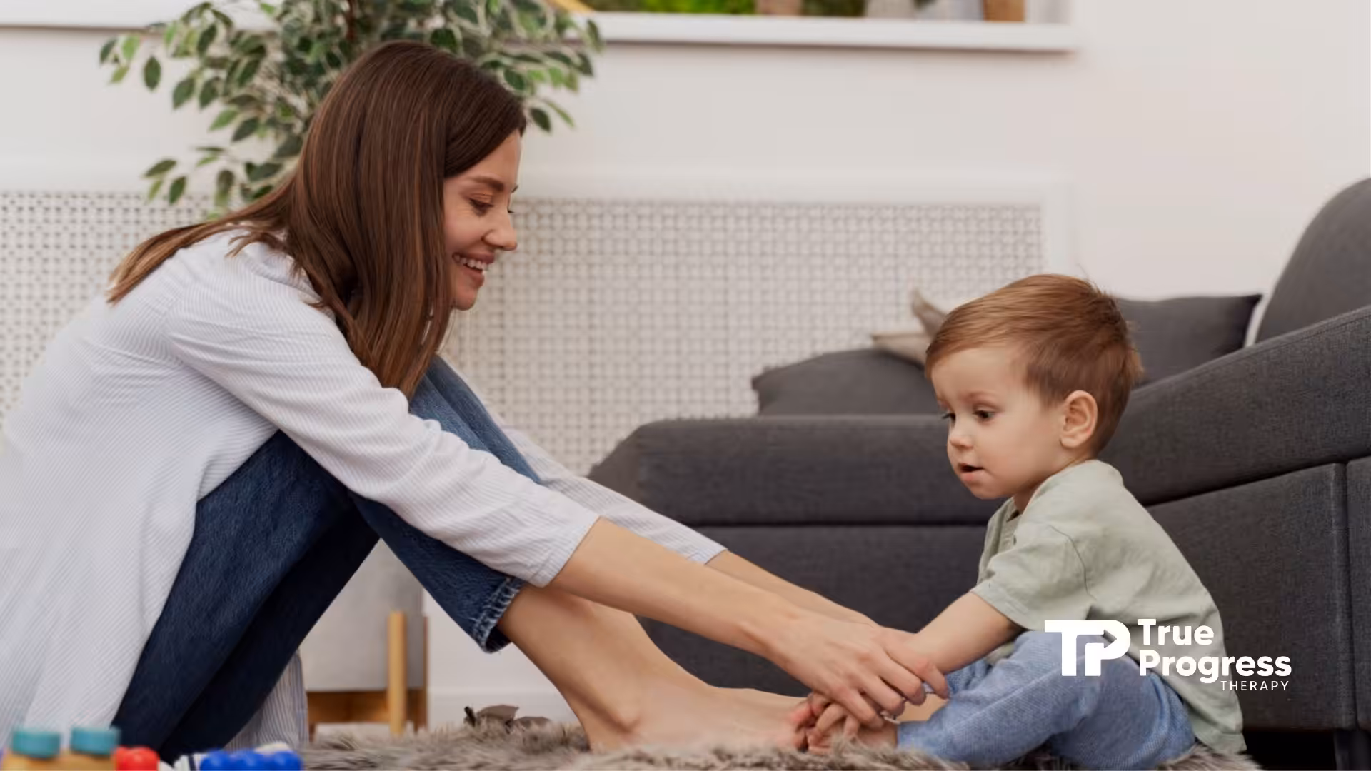 An ABA therapist assisting a toddler with a simple task.