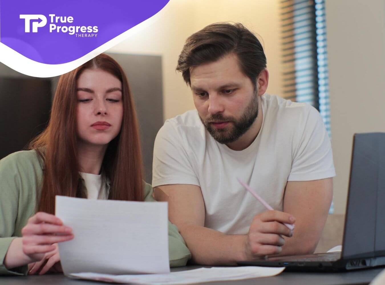Couple reviewing a Behavior Intervention Plan together at a laptop.