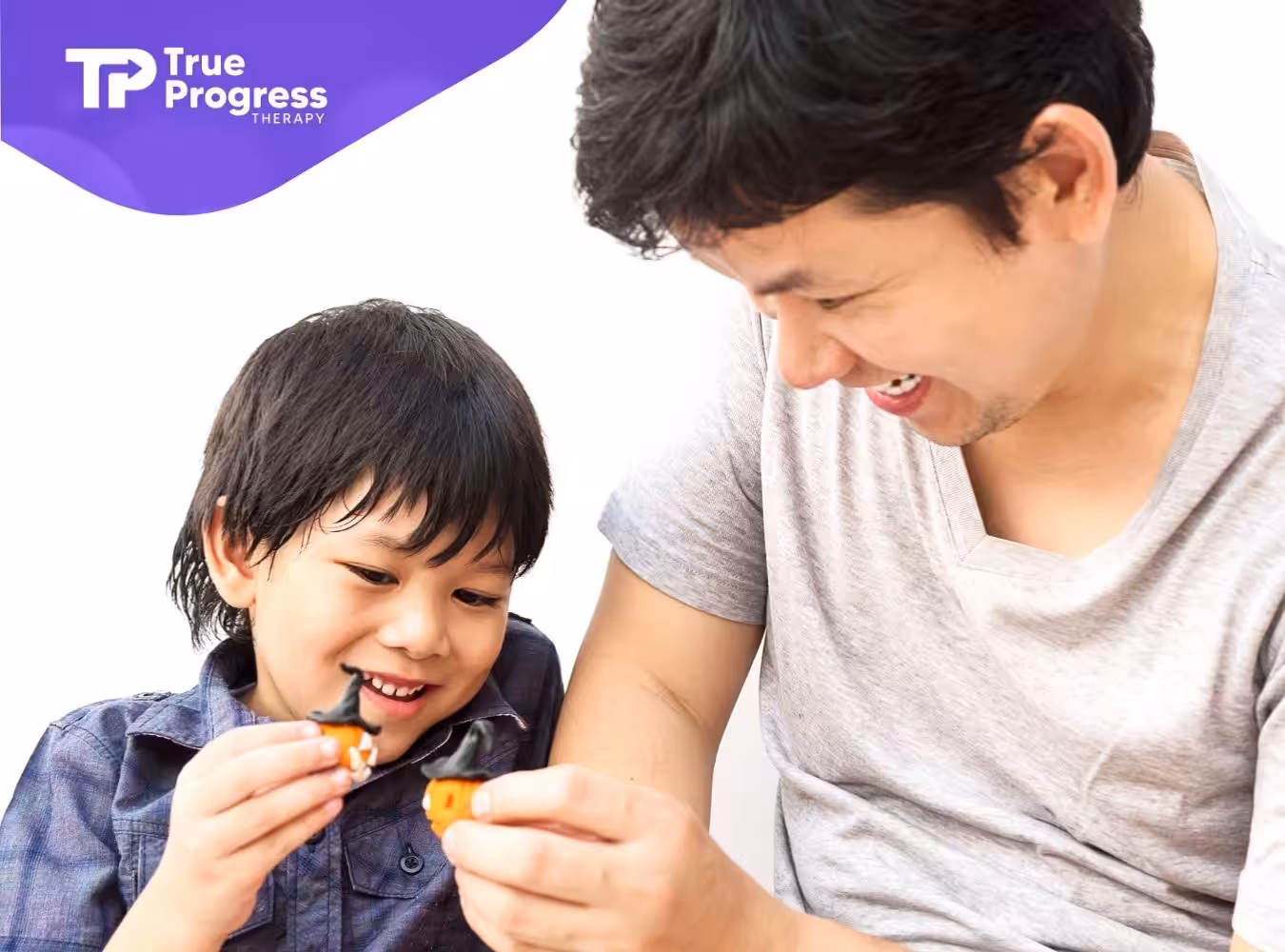 A father and son playing together, smiling, while holding small toys.