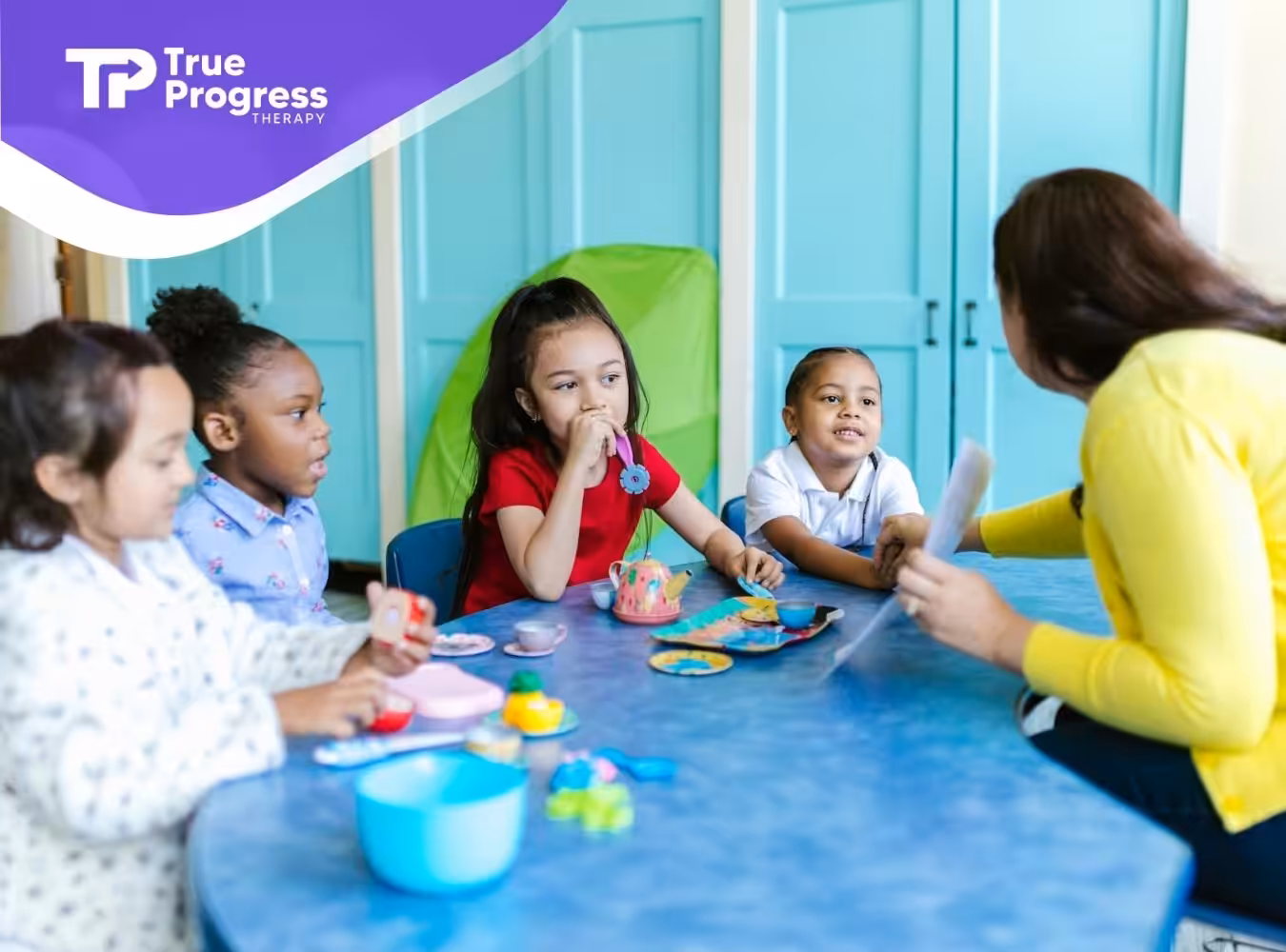 BCBA interacting with four autistic children playing with toy food at a table in a classroom in NJ.