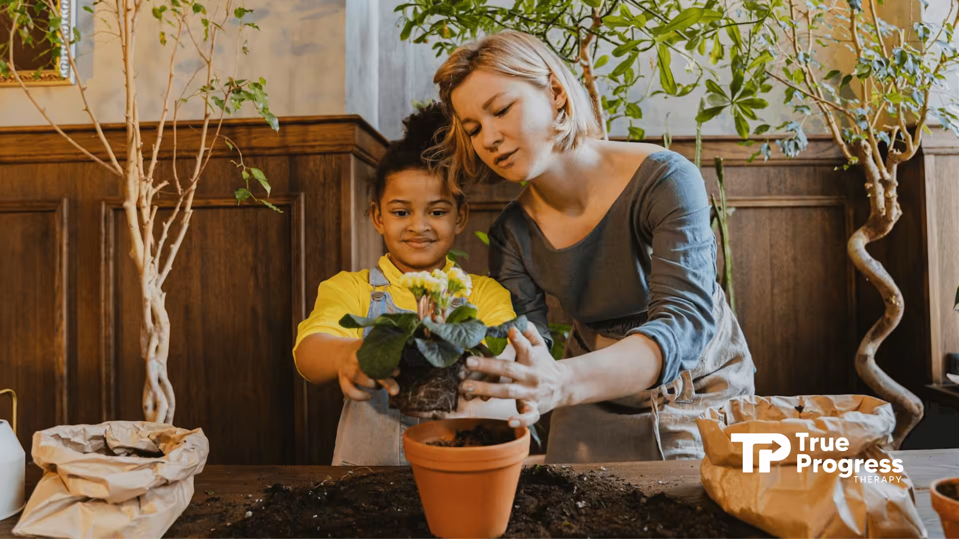 An RBT and autistic child planting a flower in a pot while surrounded by greenery during in-home ABA therapy in NJ.