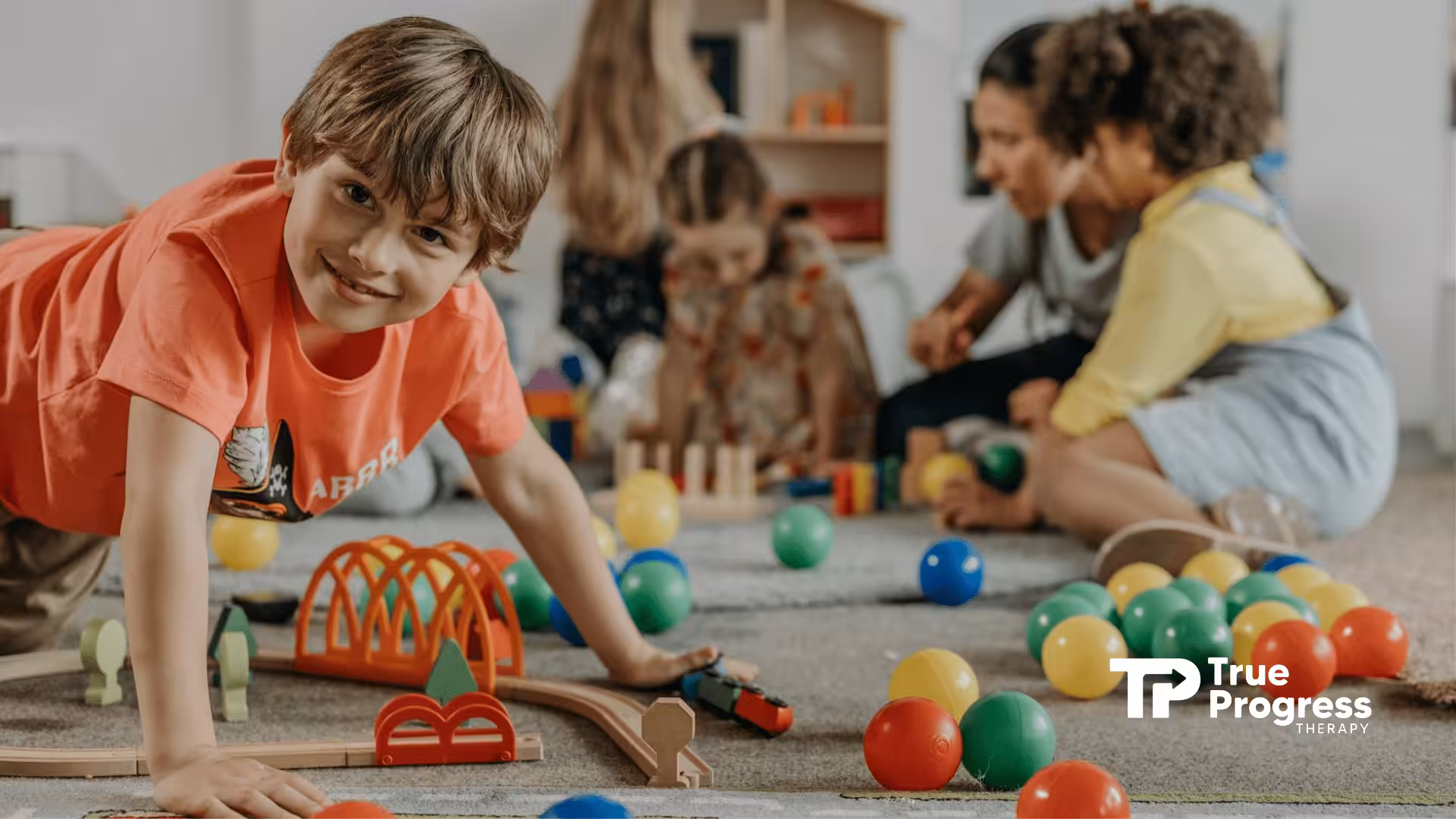 Young autistic boy smiling and playing with colorful toys at a classroom setting in New Jersey.