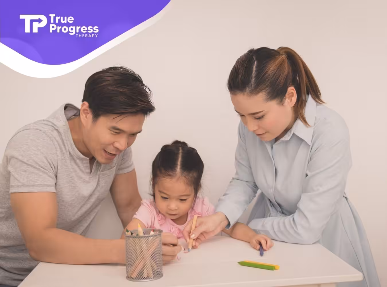 Parents and child coloring together at a table.
