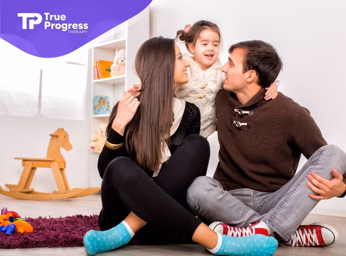 A family playing together on the floor.