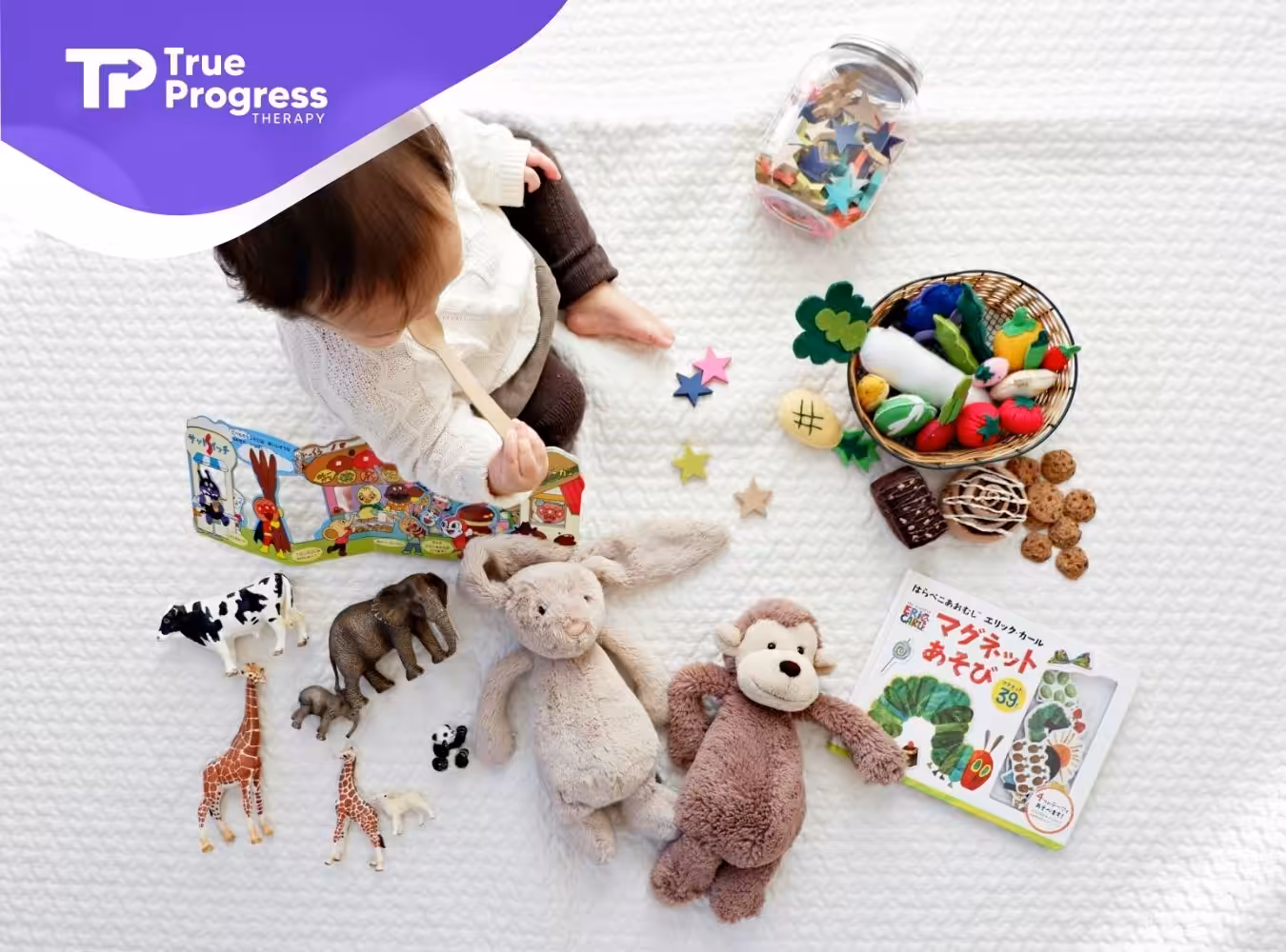 An autistic baby sitting on floor surrounded by toys and books during ABA therapy session in New Jersey