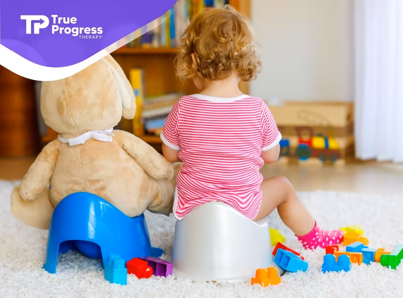 A toddler in a striped outfit sits on a potty next to a large stuffed bear on a blue potty. Toys surround them, creating a playful and warm scene.