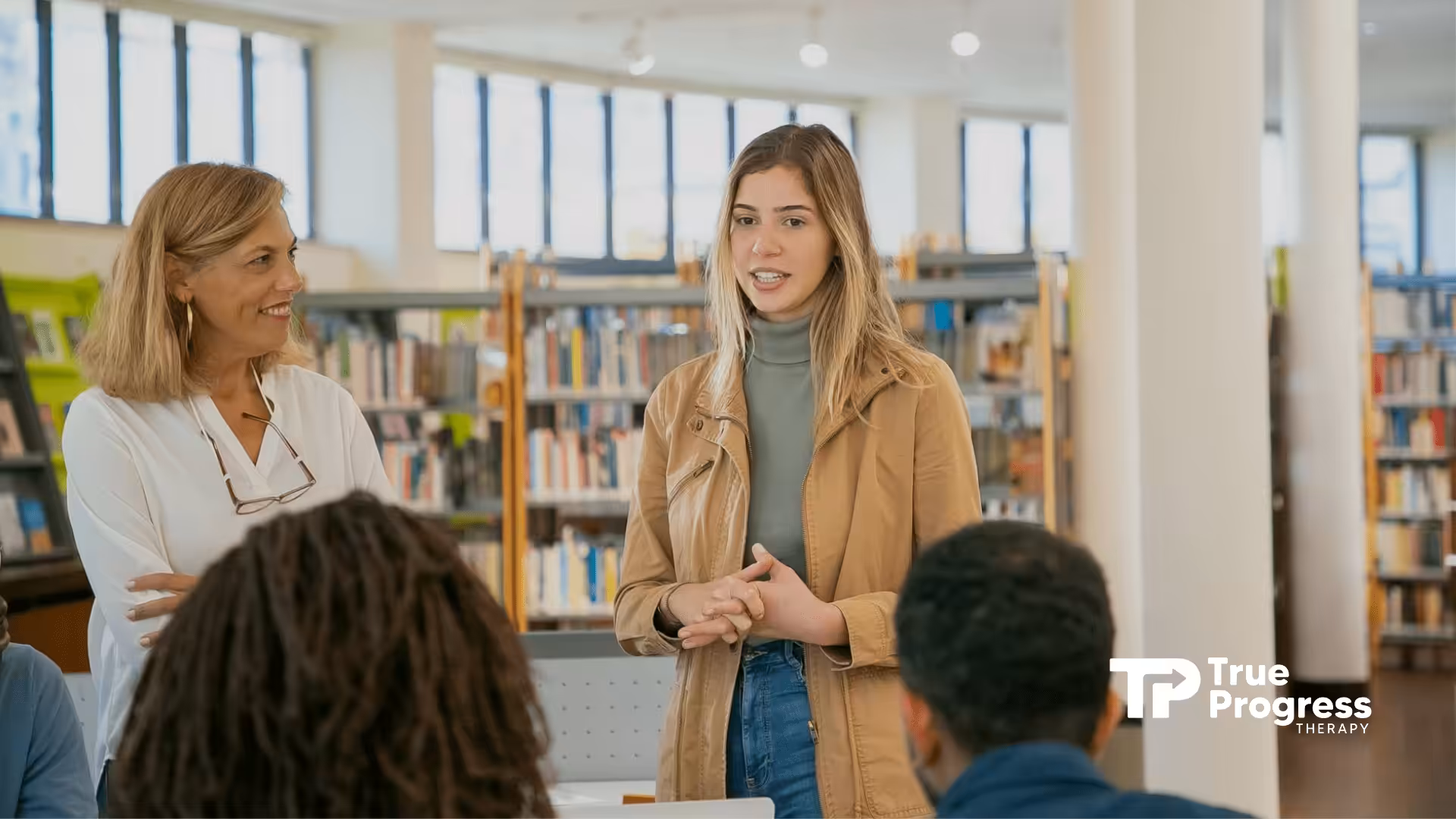 An RBT confidently speaks in a library during training while her senior and audience listen in NJ.