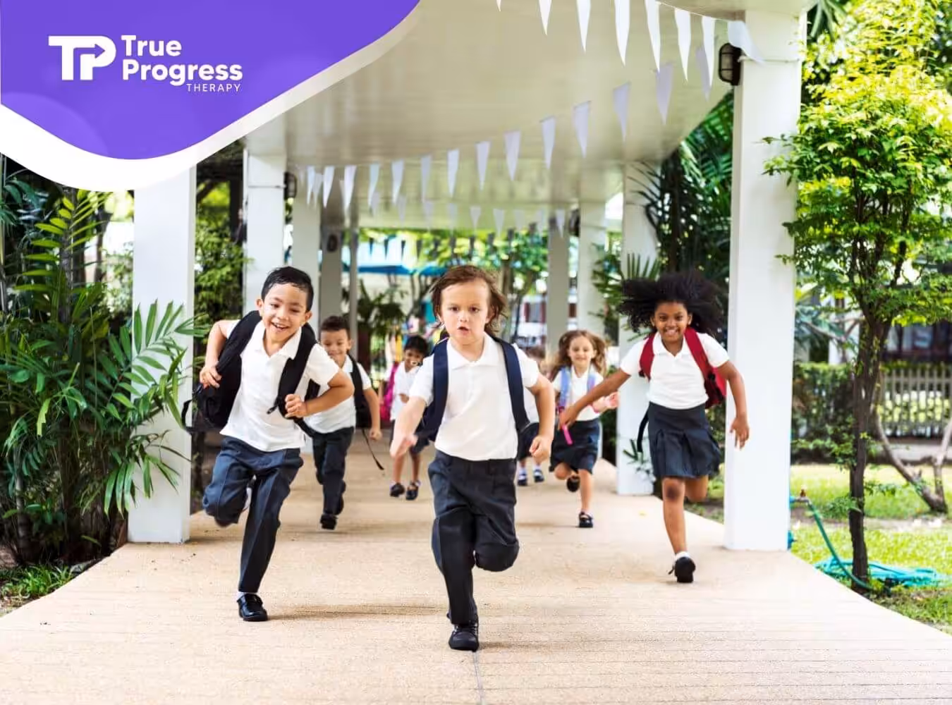 A group of children with autism run happily through a school corridor.
