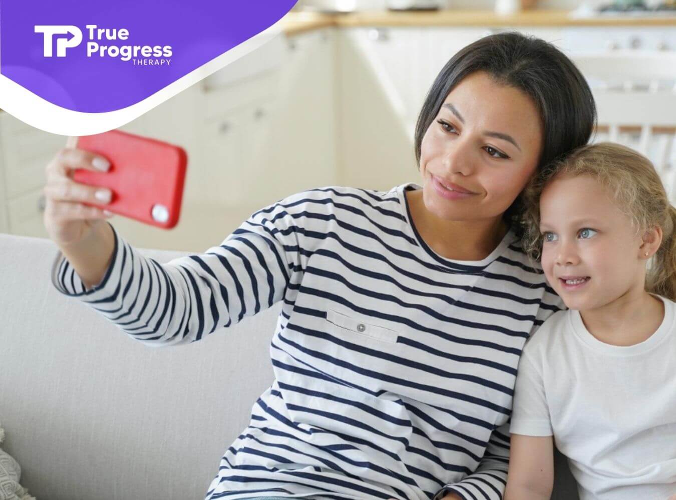 BCBA and girl with autism sitting on a couch taking a selfie after ABA therapy.
