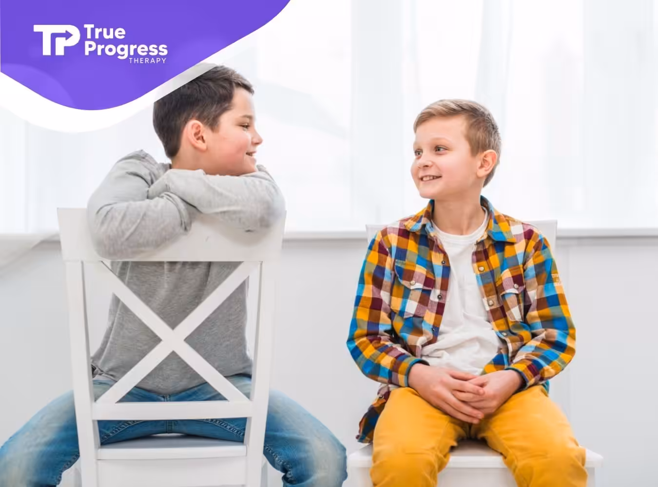 Two young boys sitting and chatting happily together.