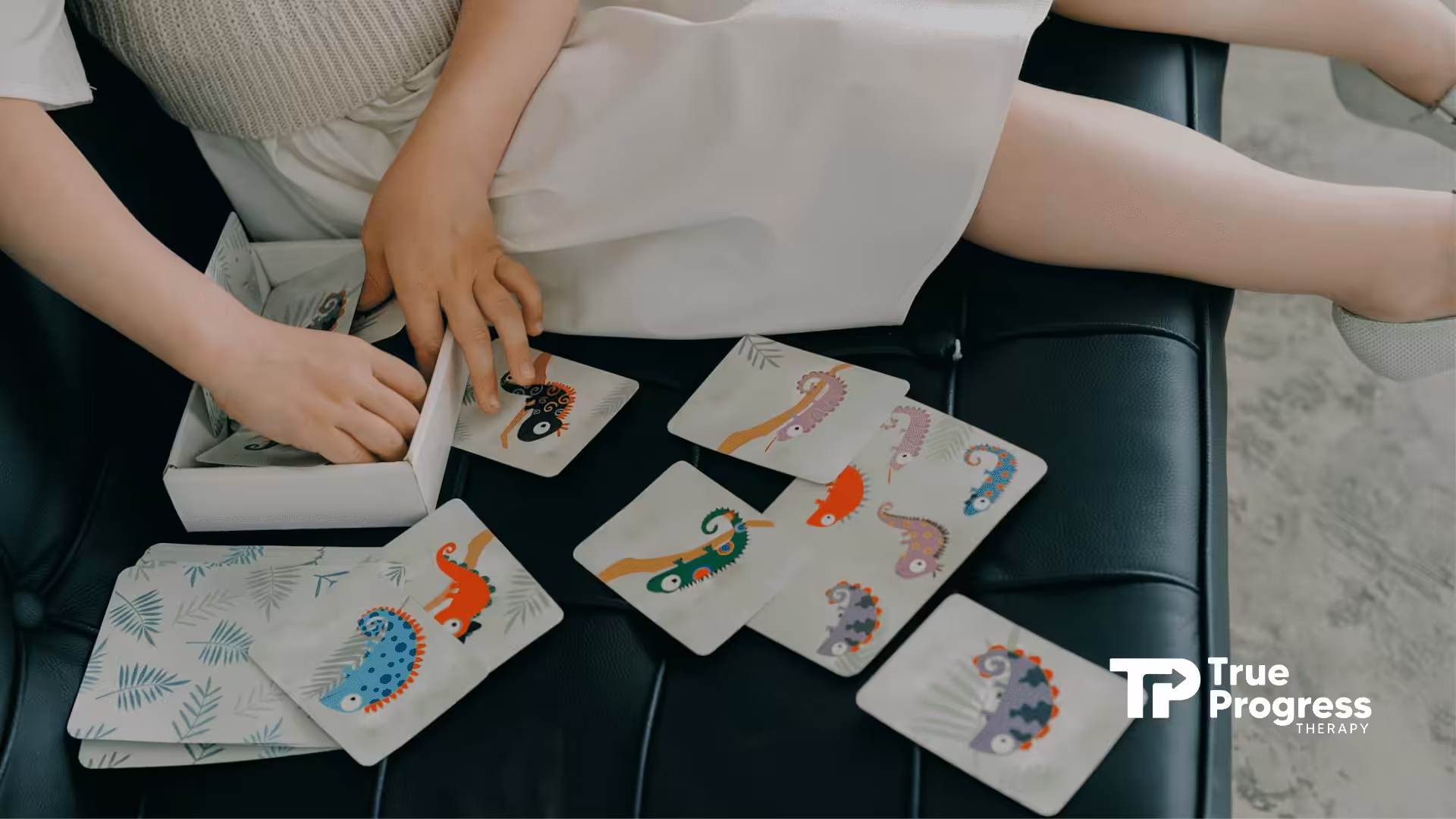 Child playing a matching card game with chameleon illustrations on a seat during ABA therapy in NJ.