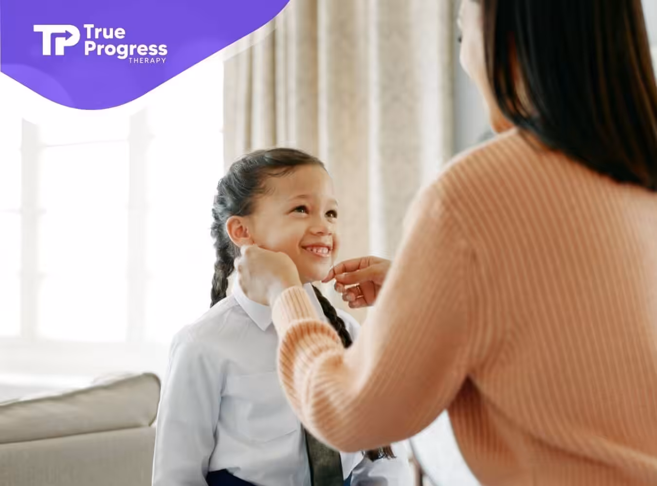 A mother helping her daughter with autism get ready, adjusting her school uniform while the girl smiles.