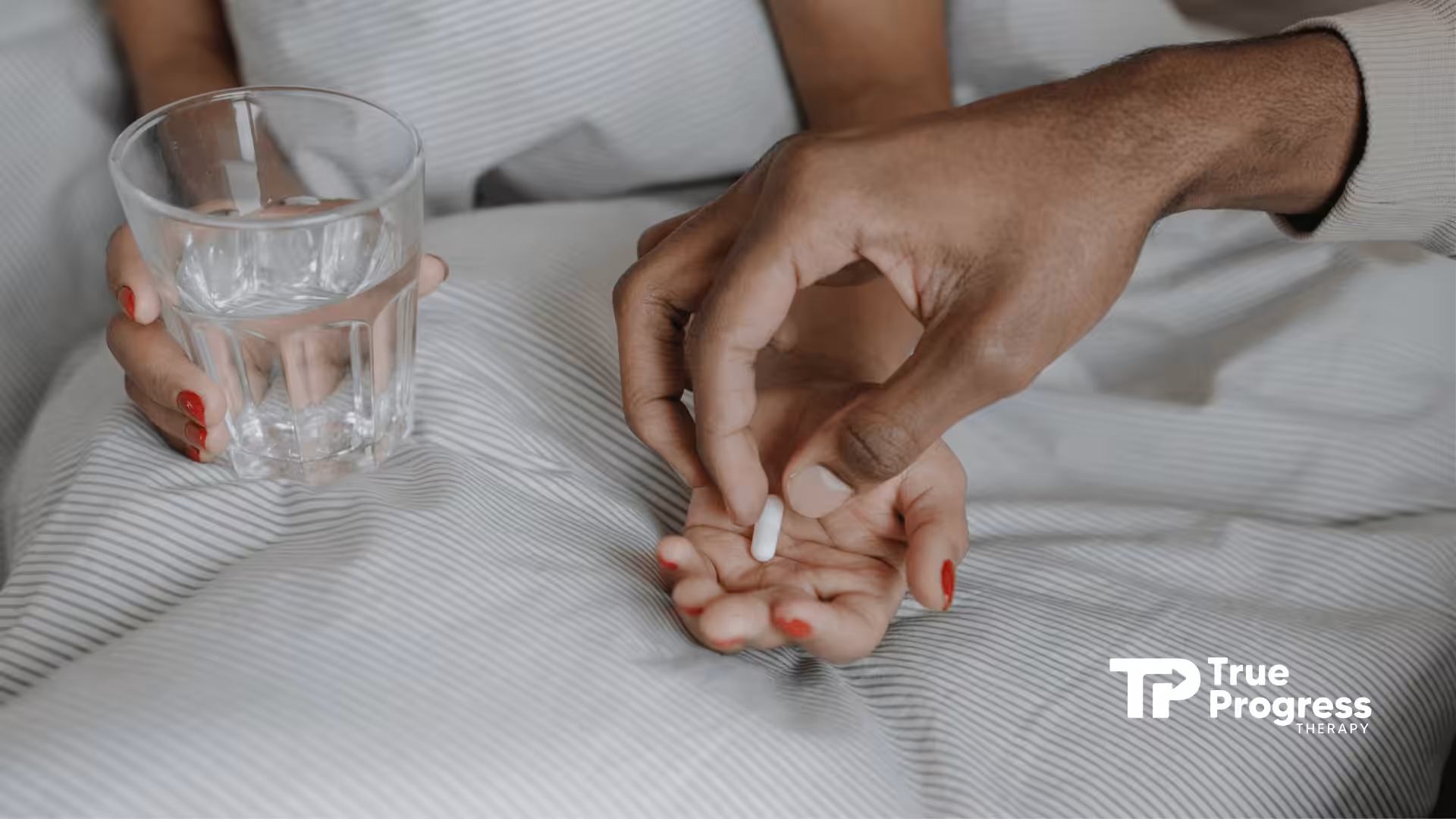 Person handing Tylenol pill to pregnant patient holding water glass even with autism risks it poses.