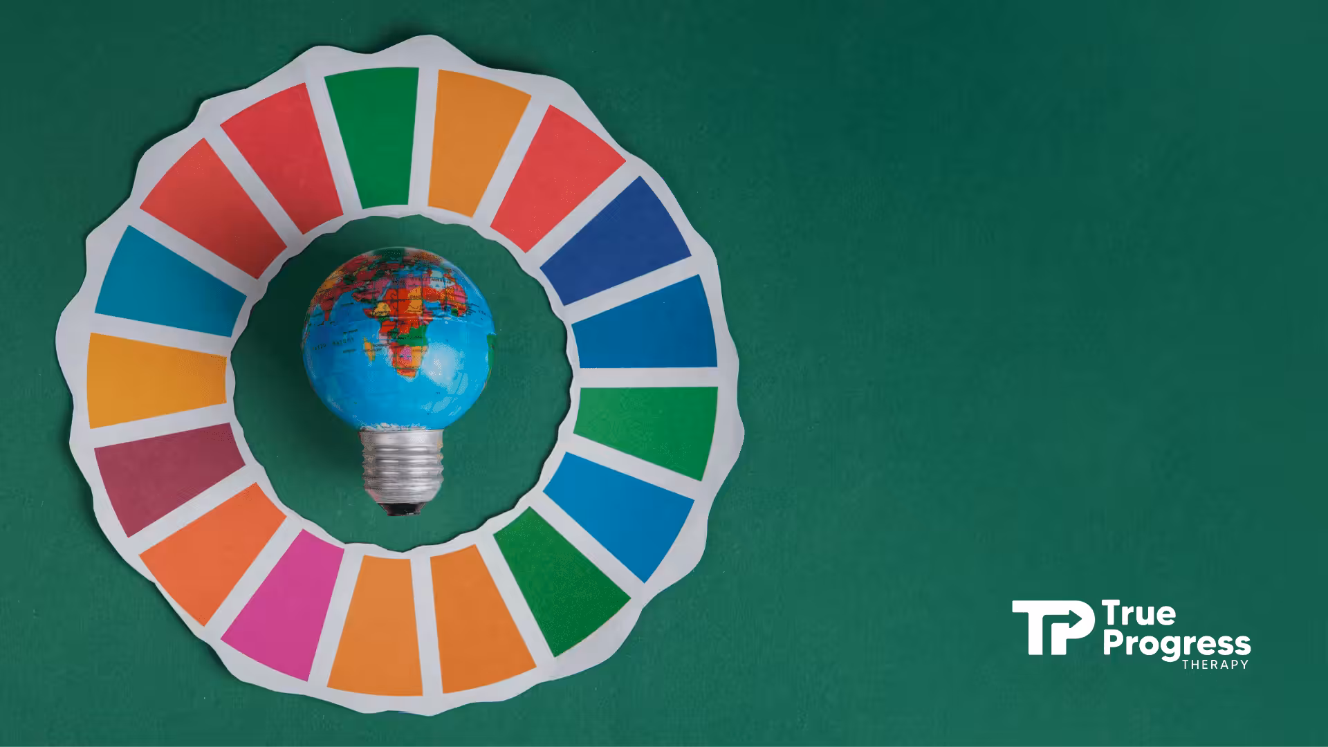 A light bulb painted with the world map inside a colorful paper wheel