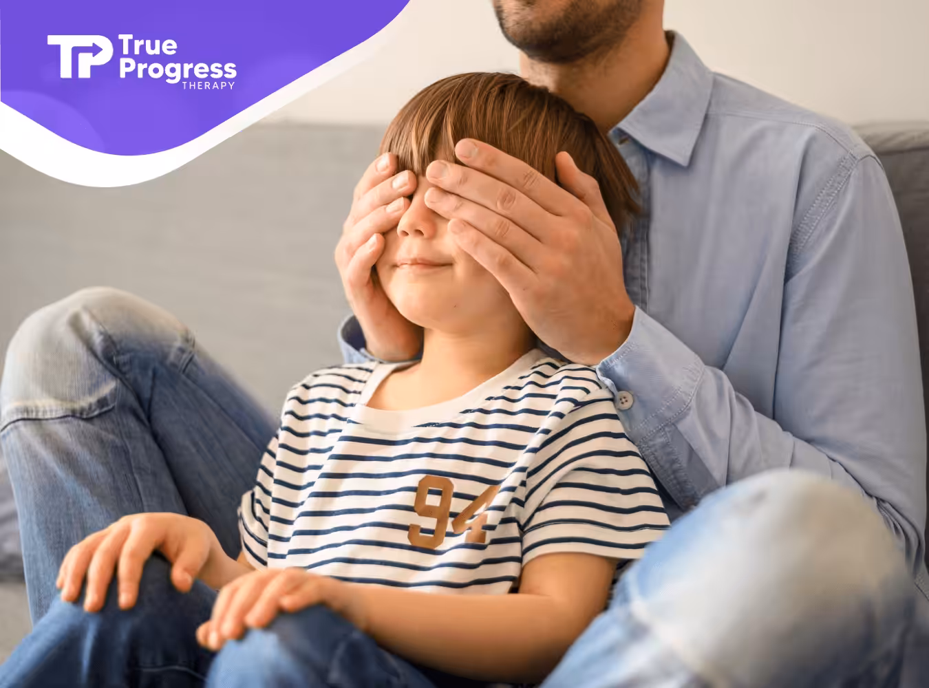 An ABA therapist is covering a child's eyes during ABA therapy