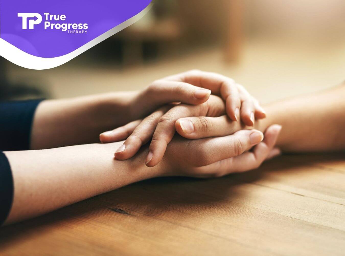 Adult gently holding a child’s hands in a supportive, calming moment during ABA therapy.