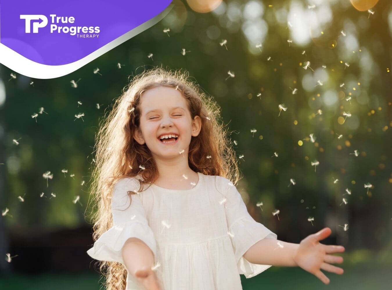 Smiling young girl outdoors surrounded by floating dandelion seeds.