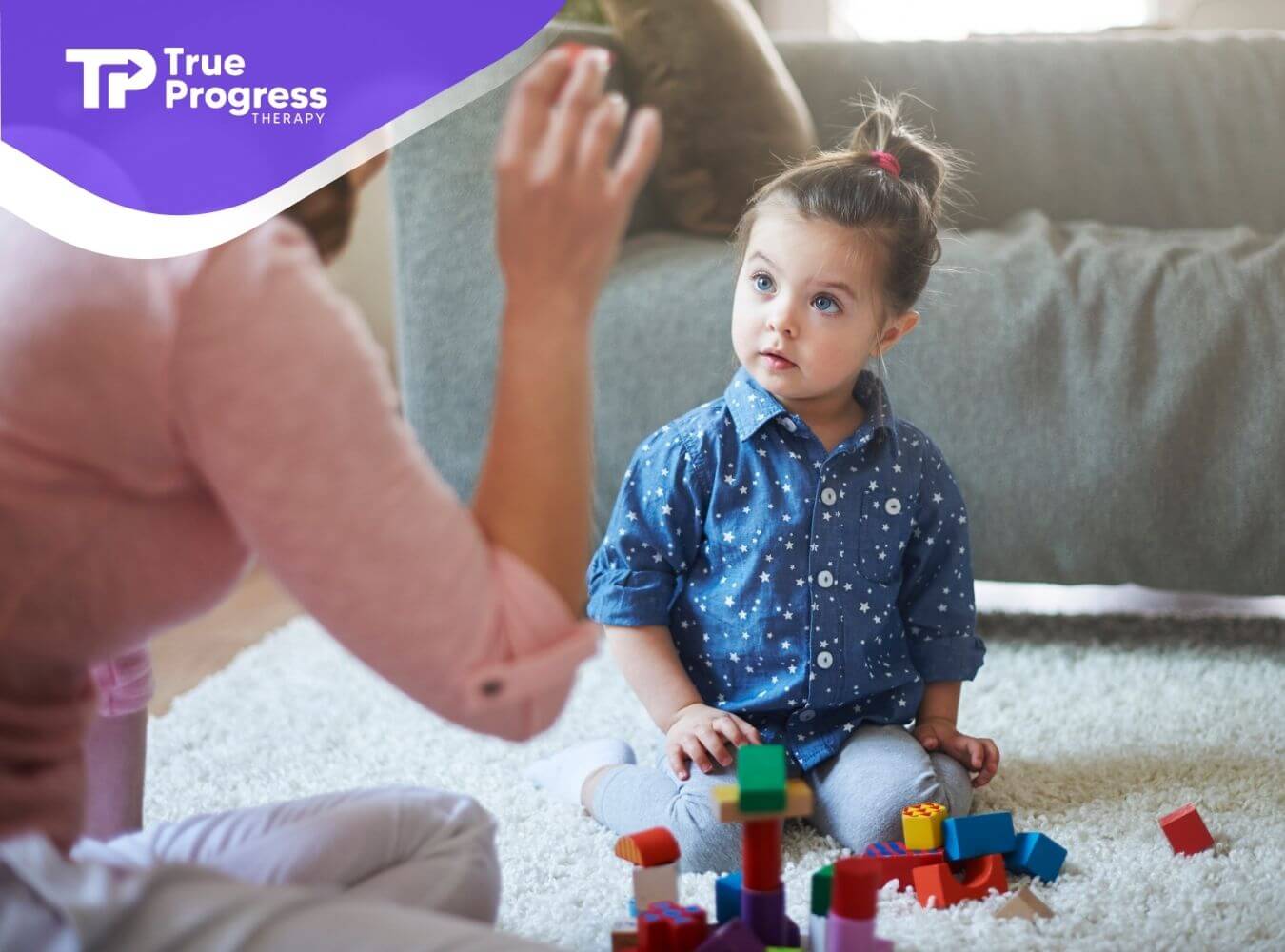 A therapist engaging to a autistic kid in play-based interaction using blocks to encourage communication.