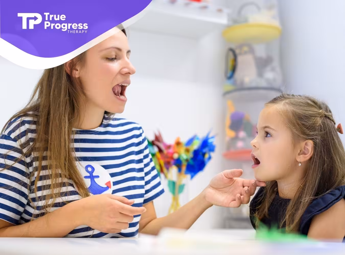 A little girl doing ABA therapy with her therapist in a clinic.