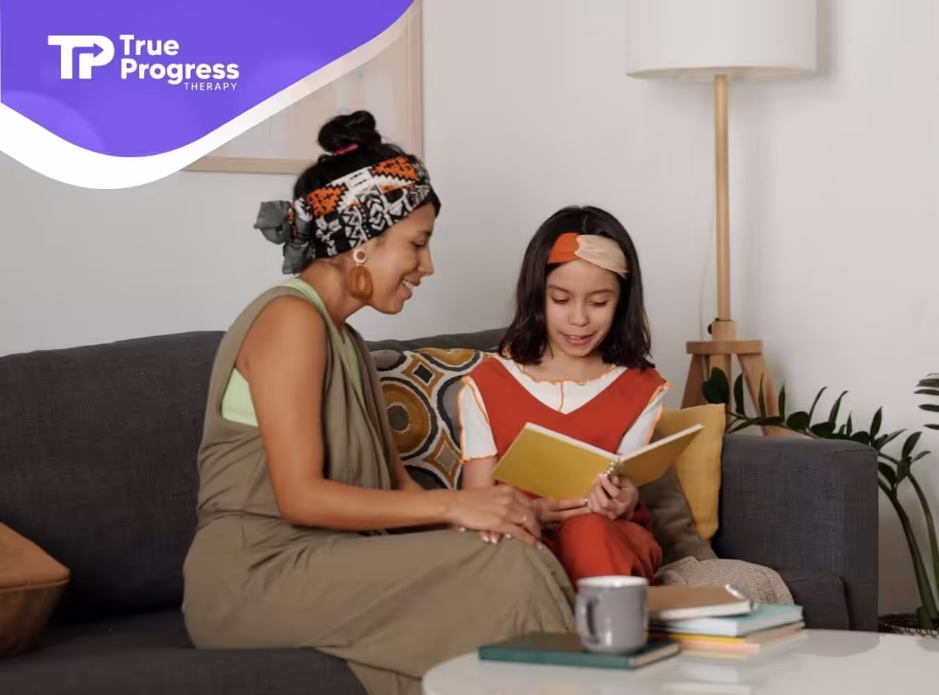 BCBA and autistic girl reading a book together on a couch in ABA therapy.