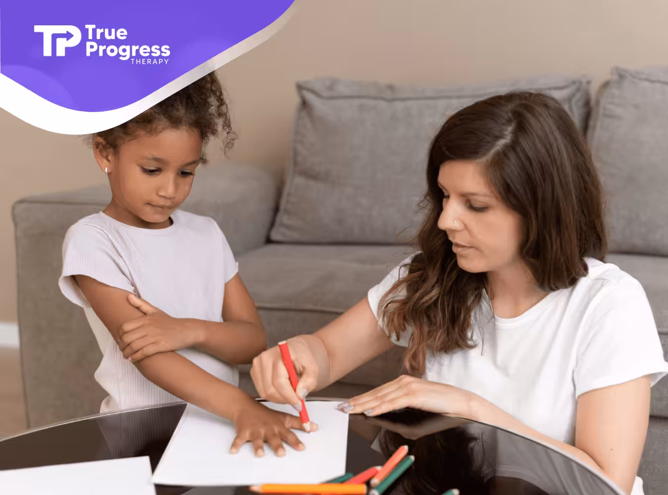 A therapist guiding a child in a drawing activity.