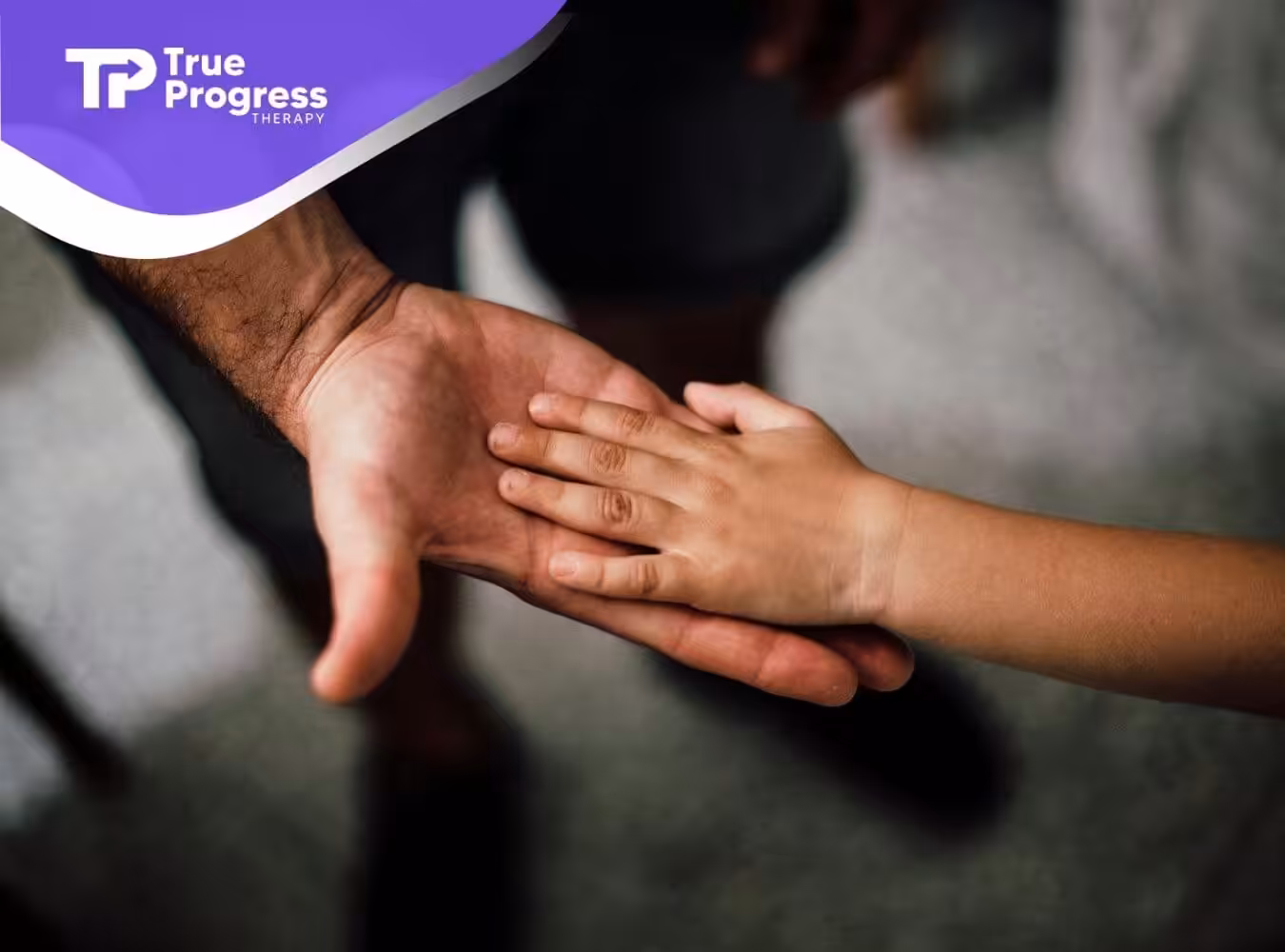 The ABA therapist and the autistic child's hands meeting in a tender gesture after ABA therapy in New Jersey.