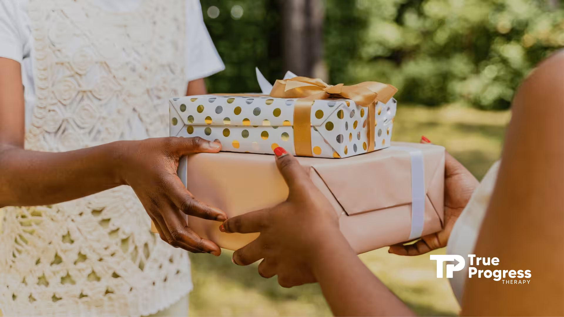 Two autistic people exchanging wrapped gifts outdoors in NJ, with a natural green background, as a way to express care.