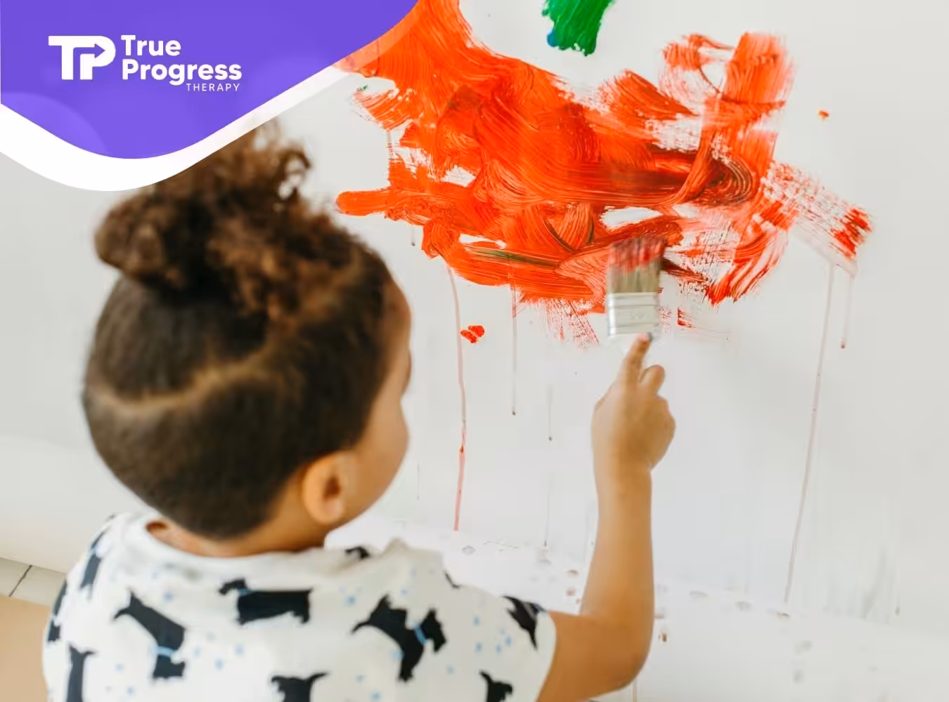 An autistic child painting on a wall with a large brush during in-home ABA therapy session in New Jersey.