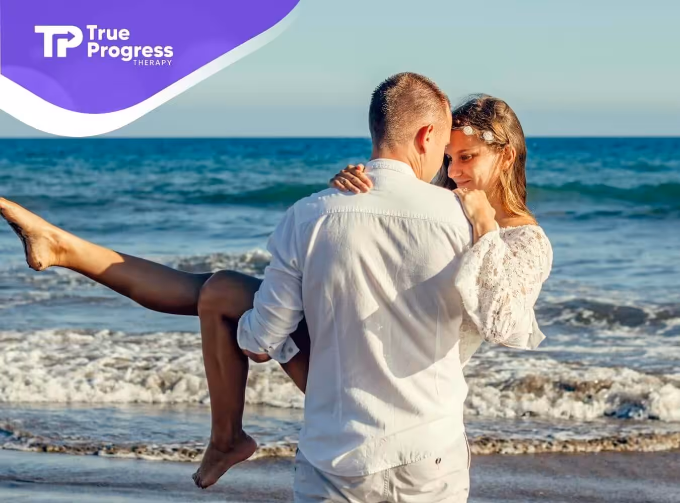 An autistic couple sharing a loving moment, with one partner lifting the other on the beach in New Jersey.