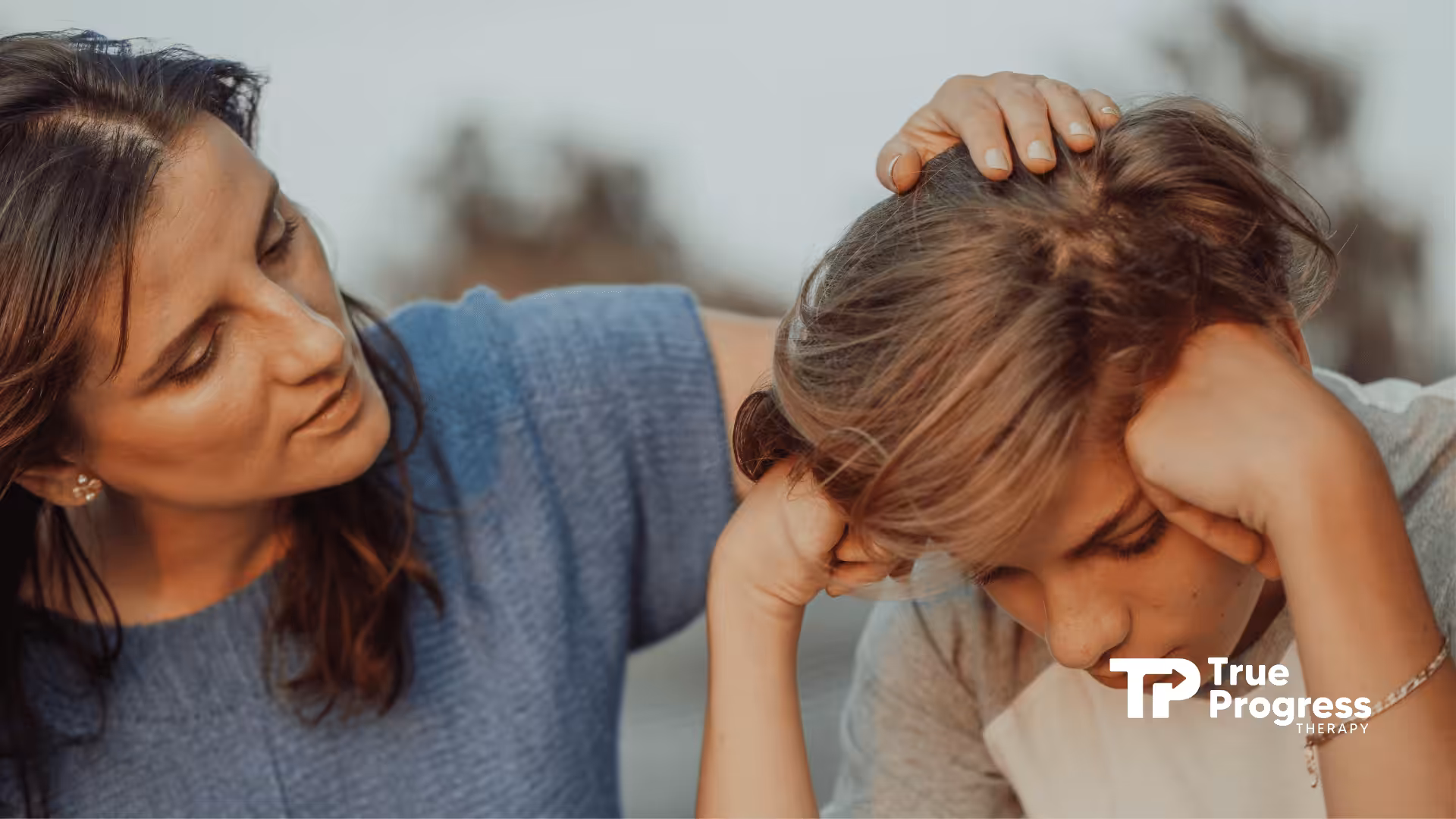 An ABA therapist comforting a teenager with autism.
