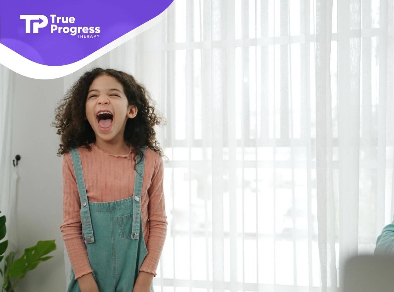 Child with autism yelling loudly indoors near window during ABA therapy.
