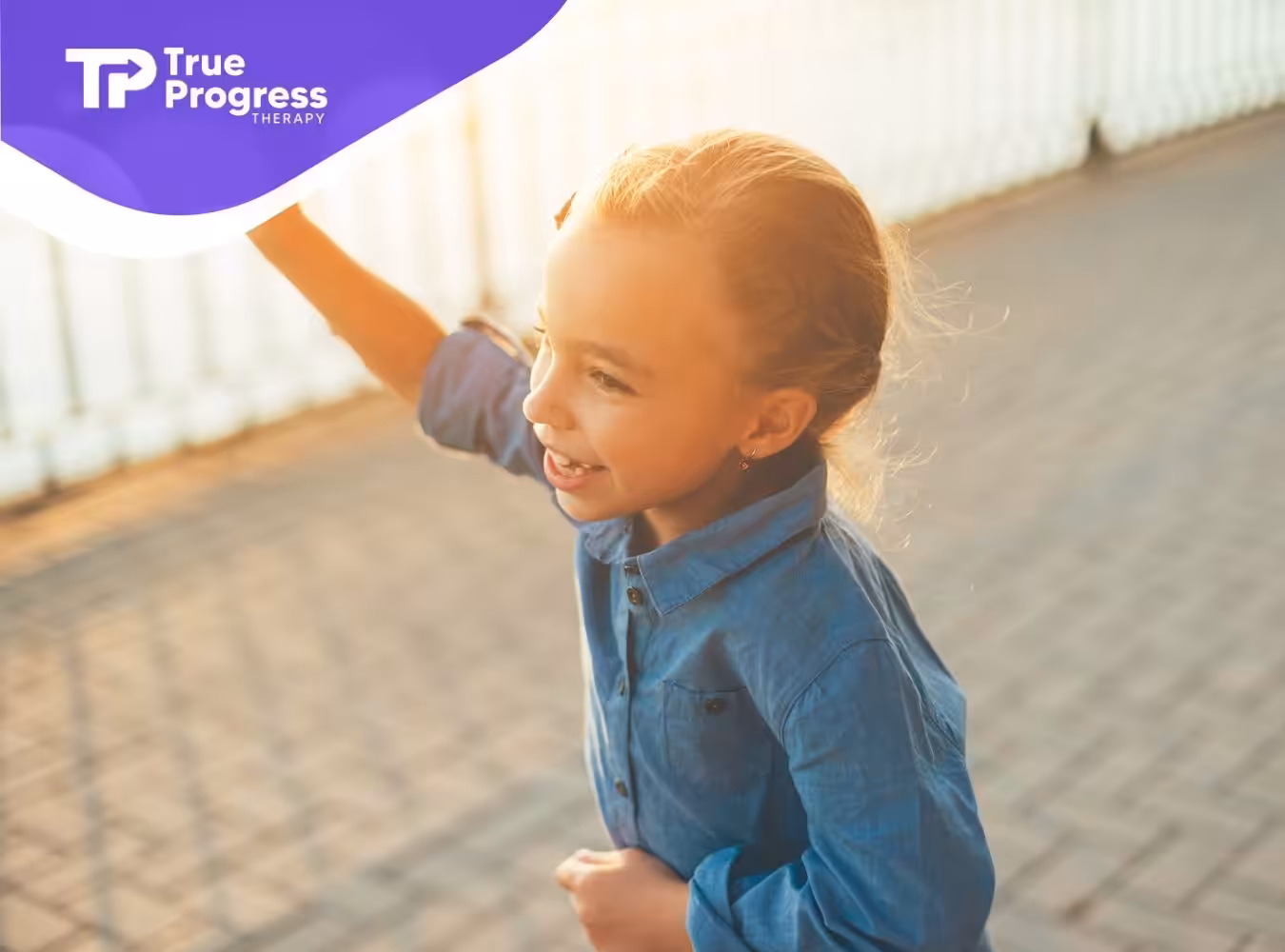 A happy girl plays with a paper airplane outdoors.