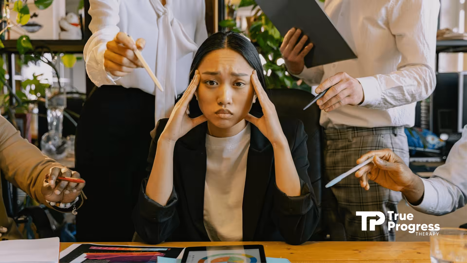 A stressed woman with autism at an office in NJ surrounded by colleagues pointing at documents.