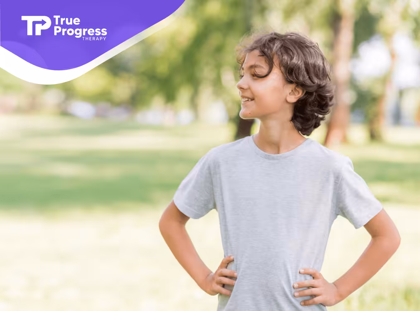 A kid standing straight with his hands on his waist