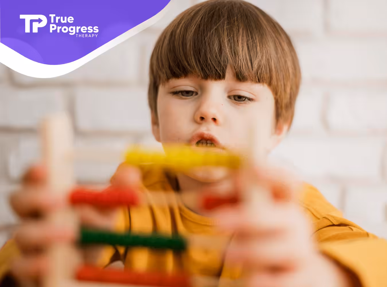 A kid with autism playing with colored wooden blocks