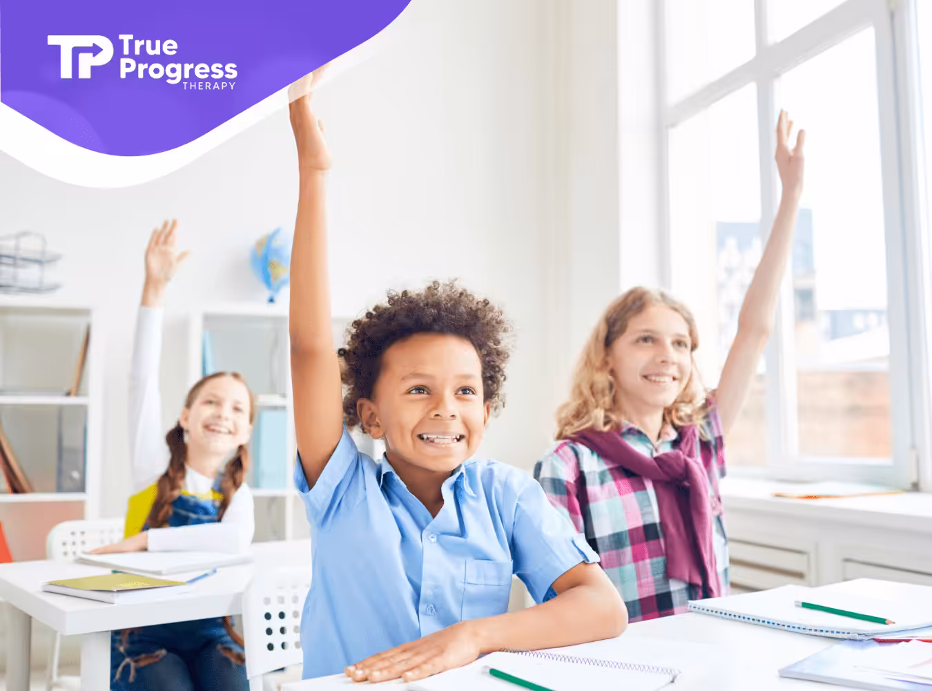 Students in a classroom raising their hands
