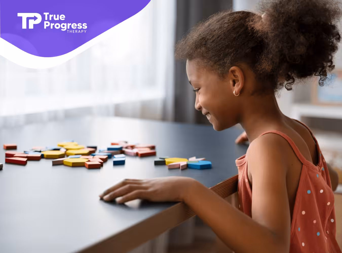 A girl with autism playing with colorful blocks on a table